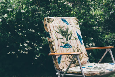 Graffiti on chair against trees