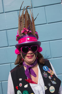 Portrait of woman wearing sunglasses standing against pink wall