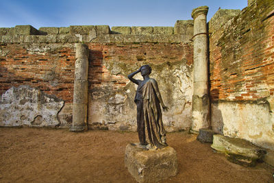 Statue of woman against wall