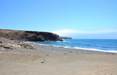 Scenic view of beach against blue sky