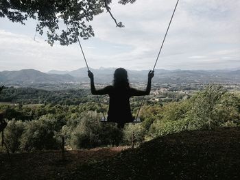 Silhouette of woman standing against cloudy sky