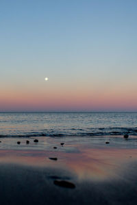 Scenic view of sea against clear sky during sunset