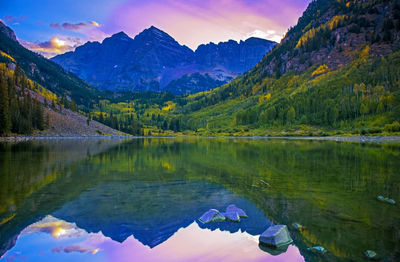 Scenic view of lake by mountains against sky