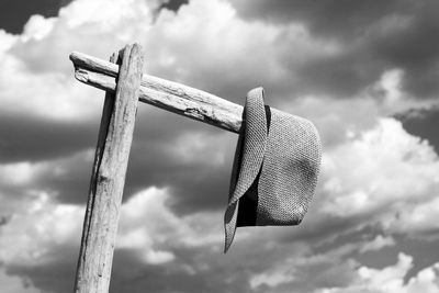 Low angle view of clothespins hanging on rope against sky