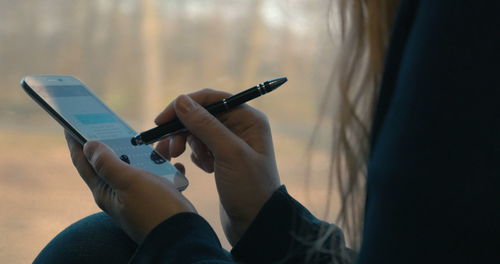 Midsection of woman using mobile phone