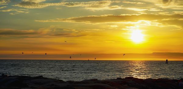 Scenic view of sea against orange sky