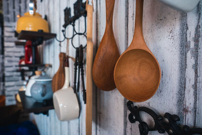 Close-up of wooden spoons hanging against wall at home