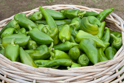 High angle view of green bell peppers in basket