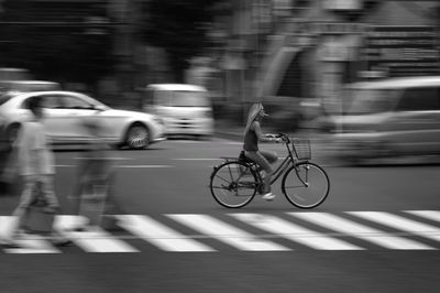 Blurred motion of man riding bicycle on road