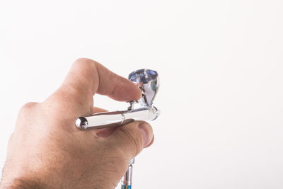 Close-up of hand holding hands over white background