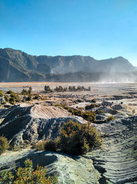 Scenic view of landscape and mountains against clear blue sky