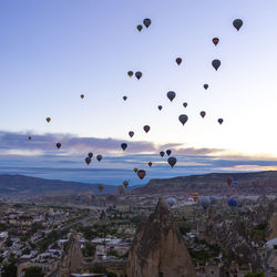 Hot air balloons flying over sea against sky