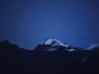 Scenic view of snowcapped mountains against clear blue sky