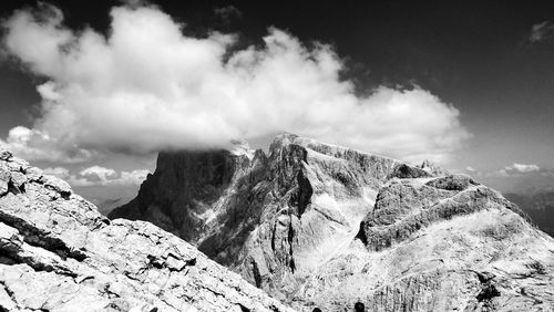 View of rocky mountains against cloudy sky