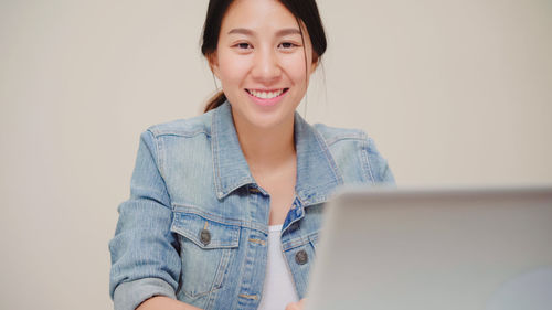 Portrait of smiling young woman using mobile phone