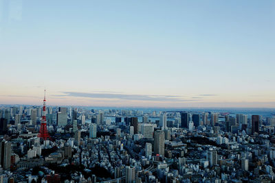 Aerial view of modern buildings against clear sky during sunset