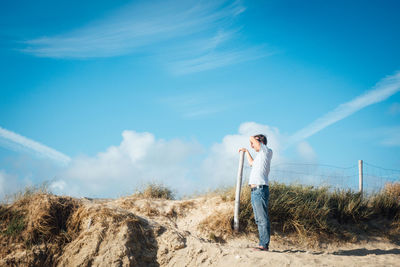 Man standing on field against sky