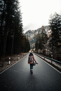 Rear view of woman walking on road