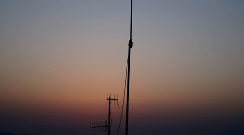 Silhouette electricity pylon against sky during sunset