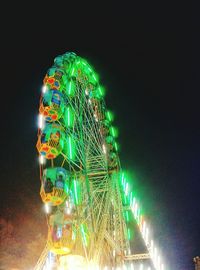 Low angle view of illuminated ferris wheel at night