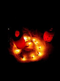 Close-up of illuminated light candles against black background