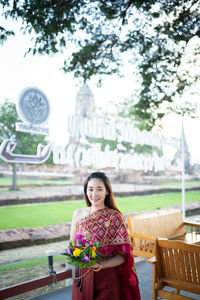 Portrait of woman standing in traditional clothing at temple