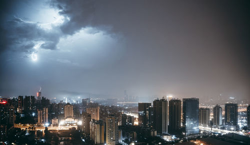 High angle view of illuminated buildings against sky at night