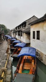 Boats moored on shore against sky