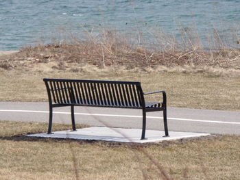 Empty bench on shore at beach