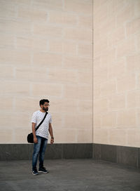 Full length of man standing against wall