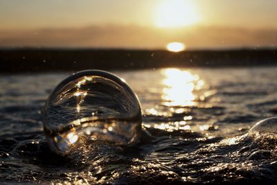 Close-up of sea against sky at sunset