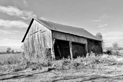 Abandoned house on land against sky