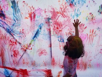 Side view of girl painting wall during holi