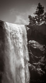 Scenic view of waterfall against sky