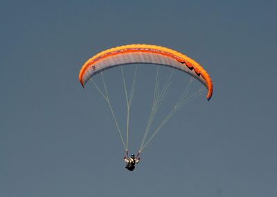 Person paragliding against clear sky