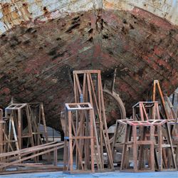 Stools under rusty ship