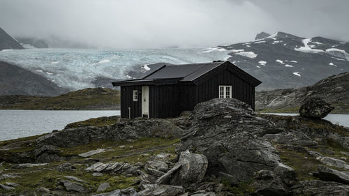 Wooden hut against snowcapped mountains