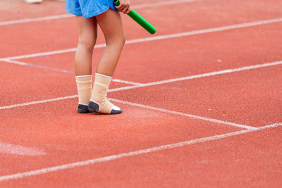 A child athlete runs a race wearing only socks.