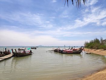 Boats moored in sea against sky