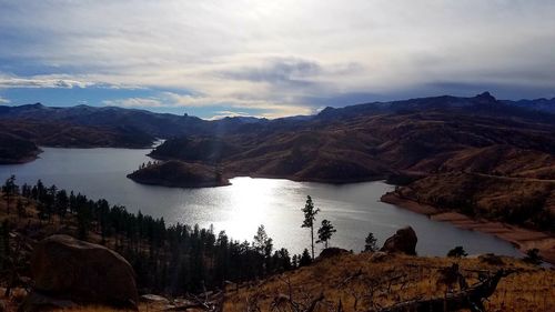 Scenic view of lake by mountains against sky