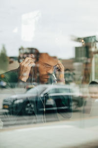 Portrait of man seen through glass window