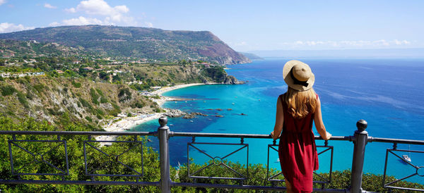 Panoramic view of elegant woman with hat in capo vaticano in the coast of the gods, calabria, italy.