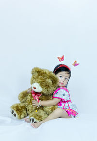 Portrait of girl with toy against white background