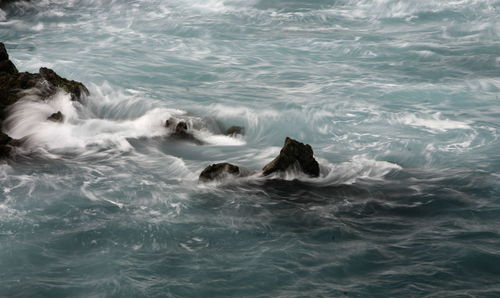 Waves crashing on rocks in sea