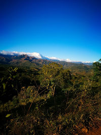 Scenic view of mountains against clear blue sky