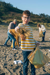 Family picking garbage while cleaning beach