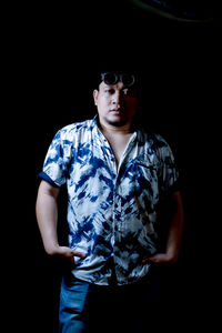 Portrait of a young man looking away over black background