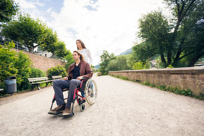 People sitting on motorcycle against sky