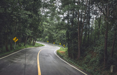 Road amidst trees in forest