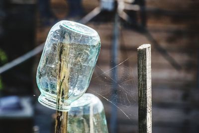 Close-up of broken glass on wooden post
